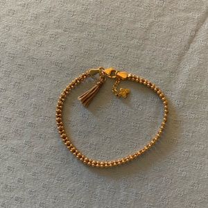 Gold bracelet with woven purple string